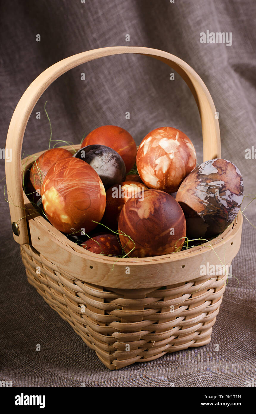 Ostern Eier. Braun bemalte Eier im Korb auf braunem Hintergrund. Stockfoto