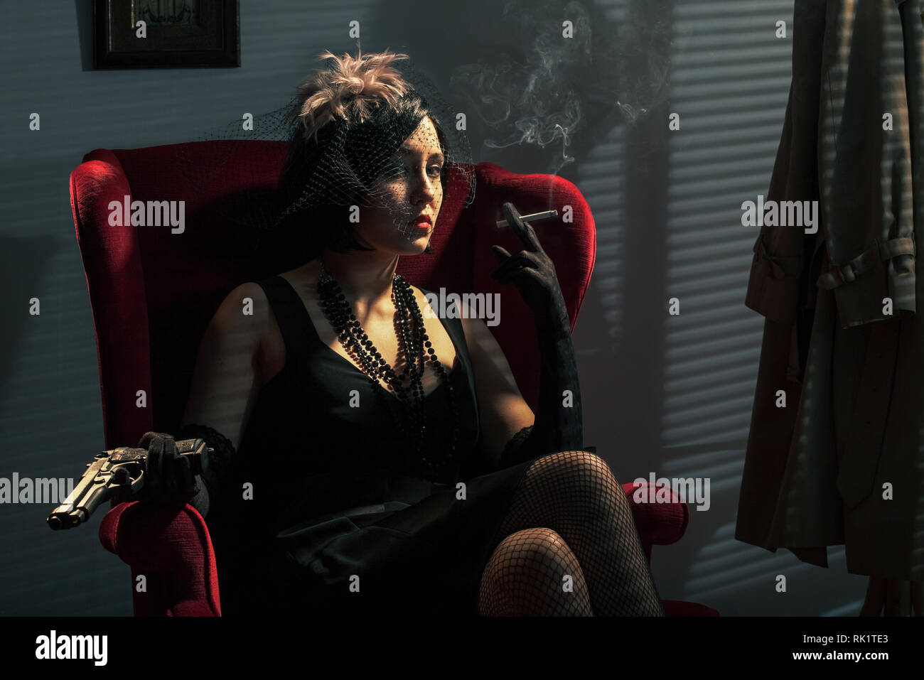 Frau mit einem Gewehr, das Rauchen einer Zigarette, Film Noir Stil Stockfoto
