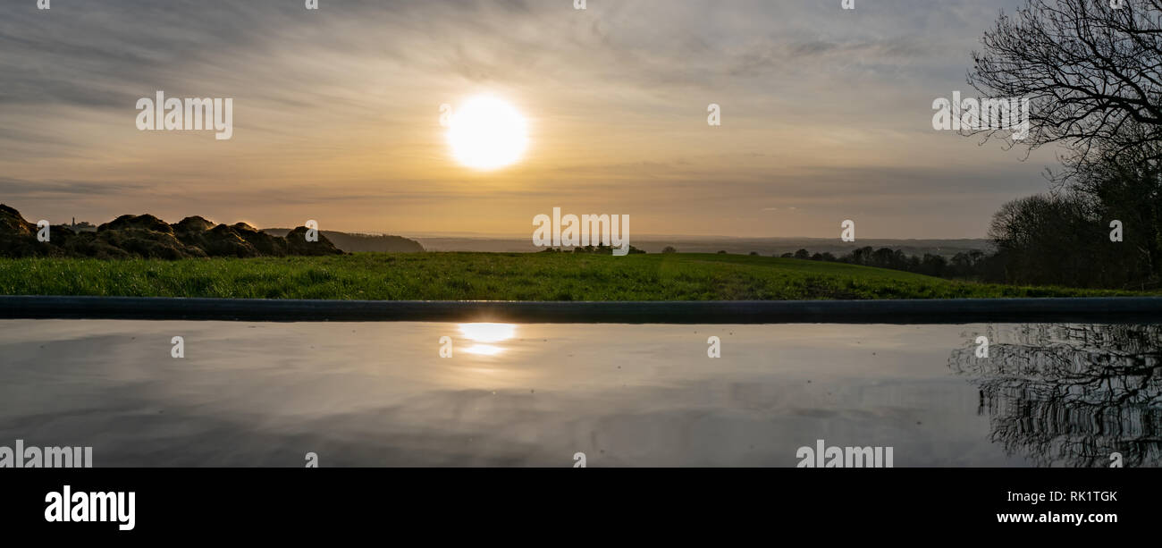 Sun setzt auf der Cotswolds, dampfenden Haufen Gülle und Reflexionen in einem Wassertrog, Gloucestershire, Vereinigtes Königreich Stockfoto