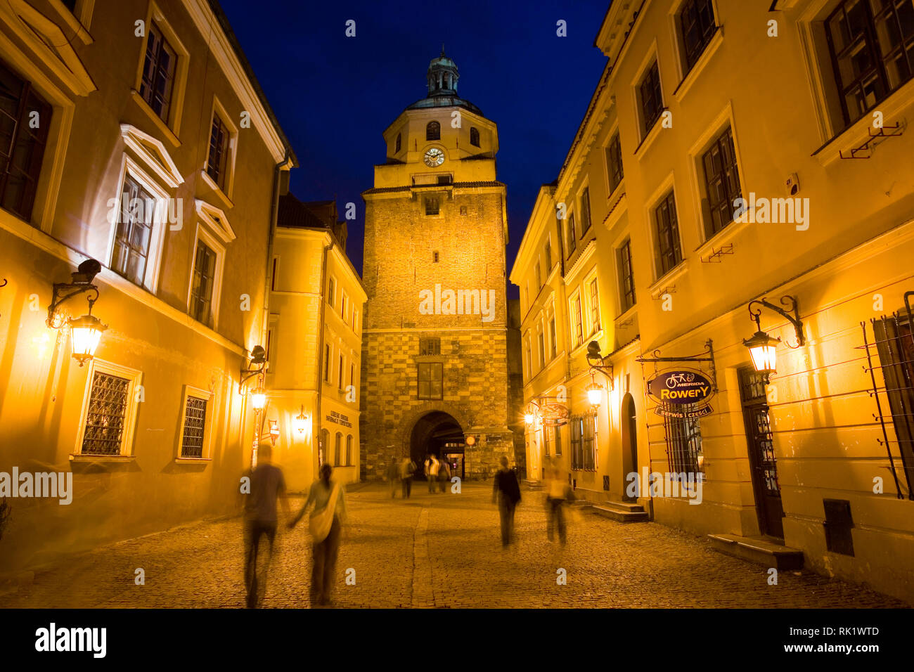 Lublin, Polen; im 14. Jahrhundert Brama Krakowska (Krakauer Tor) und Trinity Tower in der Abenddämmerung. Stockfoto