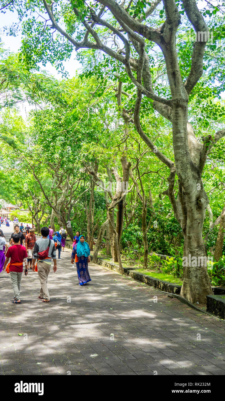 Touristen entlang eine breite Allee zu Uluwatu Tempel, Bali, Indonesien. Stockfoto