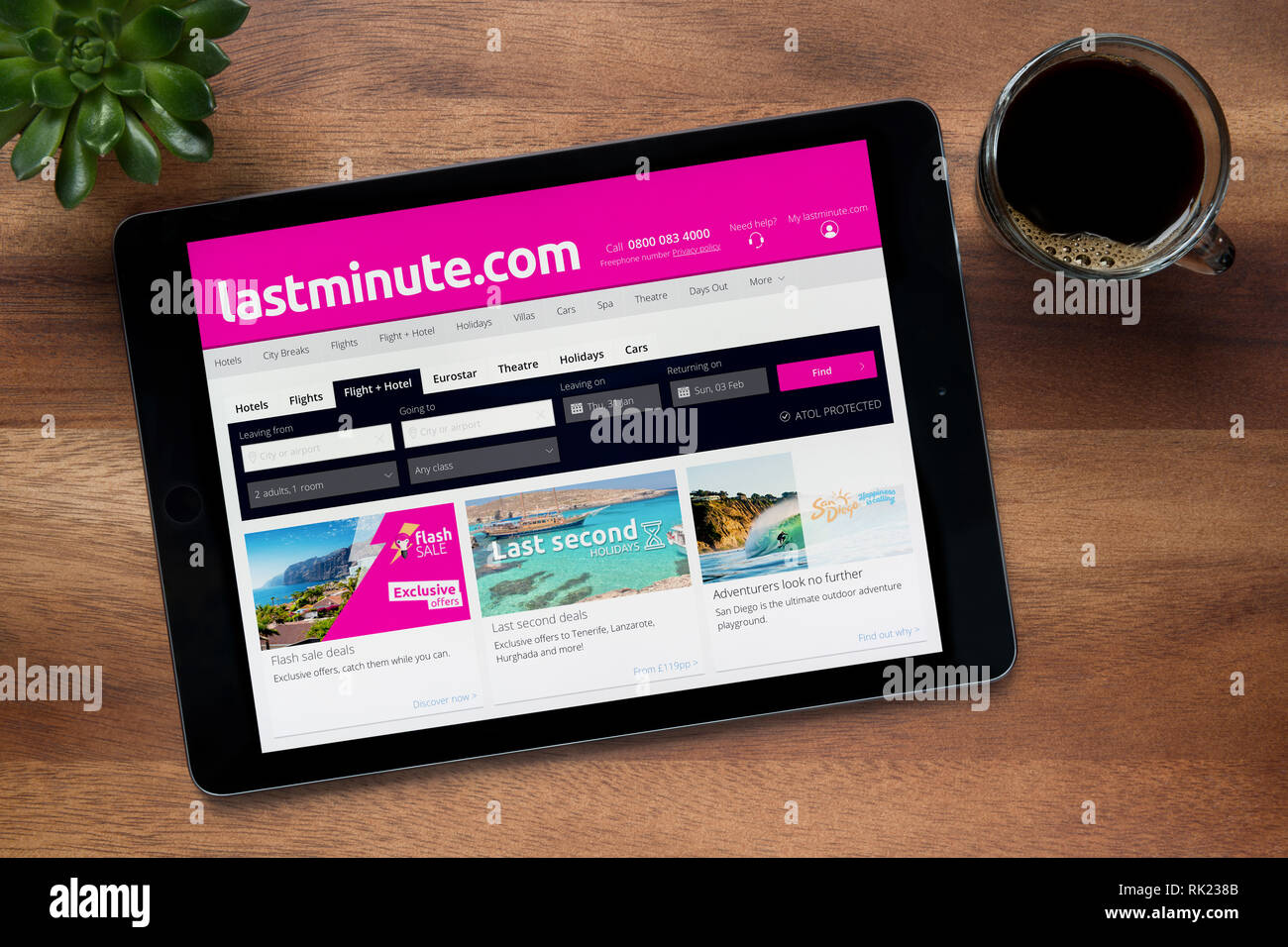 Die Website von Lastminute.com ist auf einem iPad Tablet gesehen, auf einer hölzernen Tisch zusammen mit einem Espresso und einem Haus Anlage (nur redaktionelle Nutzung). Stockfoto
