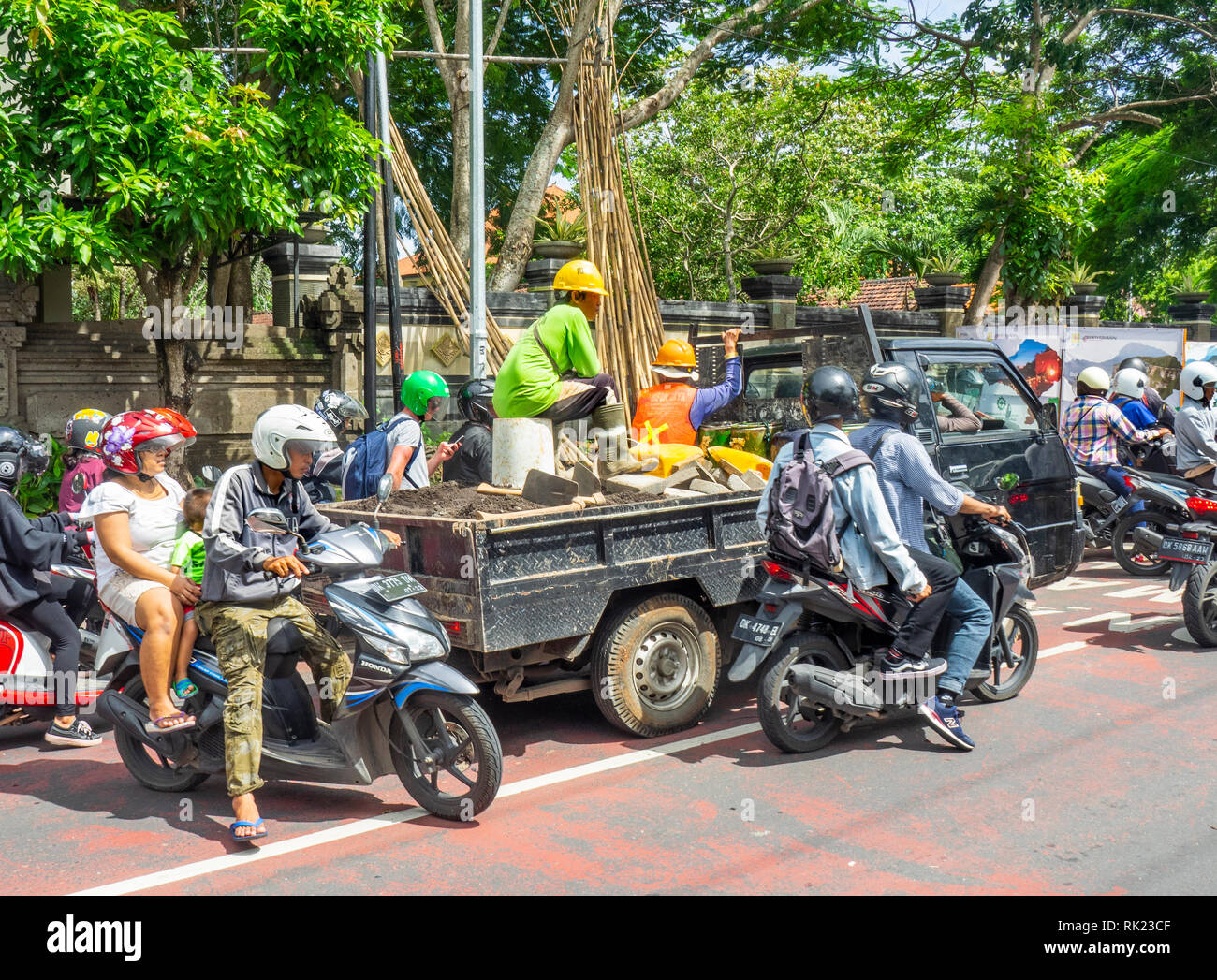 Verkehrsstaus Motorradfahrer reiten um ein Fahrzeug in Jimbaran, Bali, Indonesien. Stockfoto