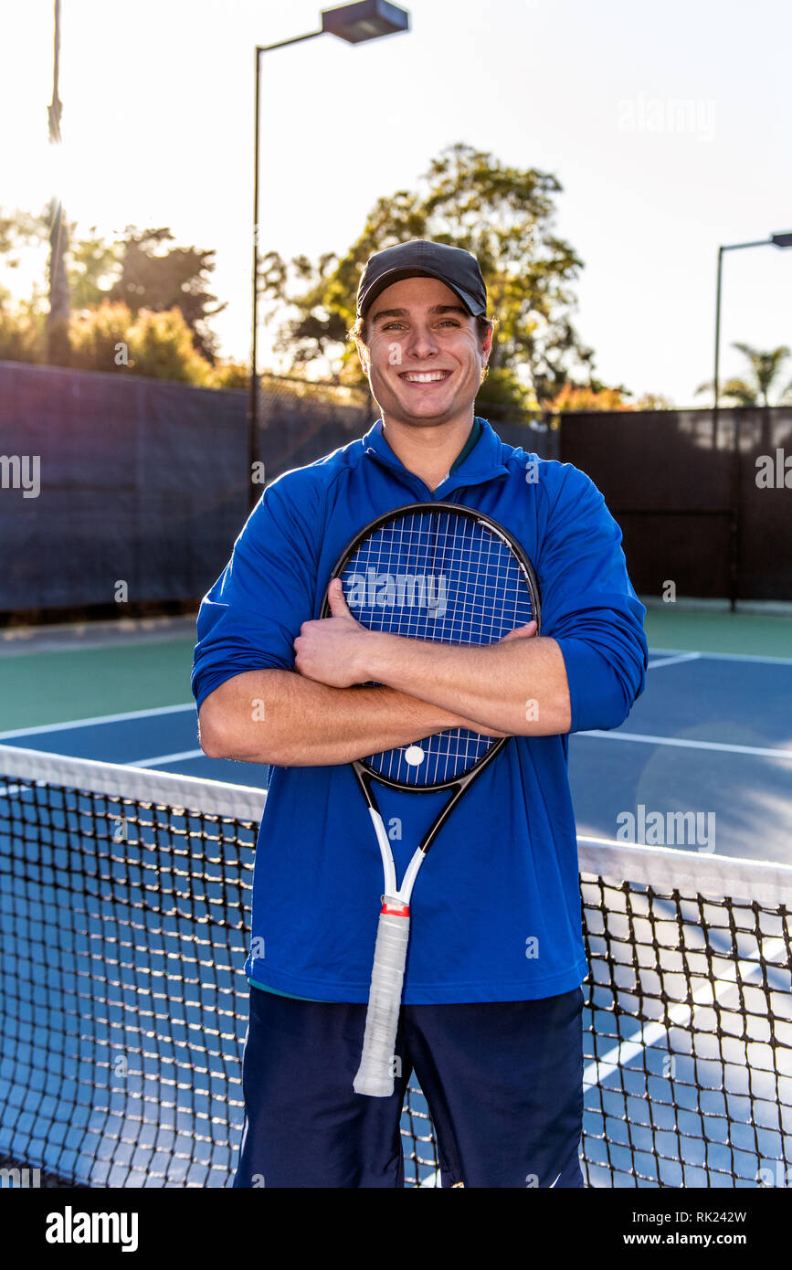 Ansicht schließen von jung und gut aussehend Tennis Unterricht professionelle zeigen, lächeln und glücklich Ausdruck auf dem Tennisplatz. Stockfoto