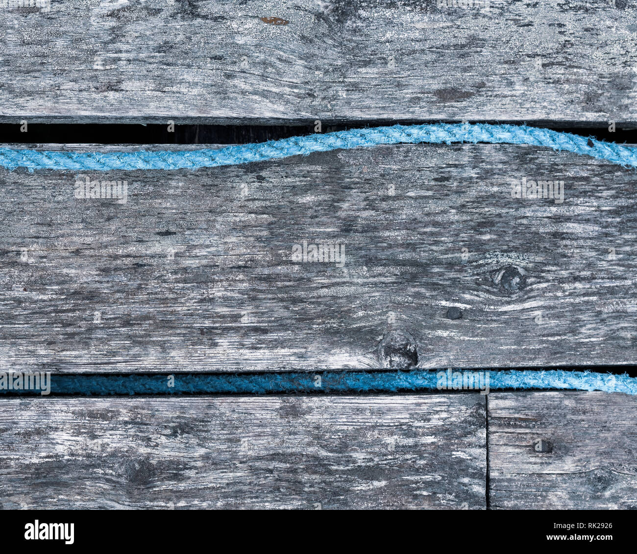 Verwitterte horizontale Holzverkleidung mit blauen Seil, Vollbild, Nahaufnahme Stockfoto