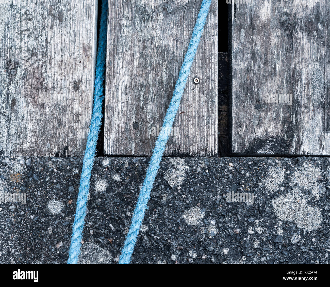 Verwitterte Holzbohlen und Beton mit blauen Seil, Vollbild, Nahaufnahme Stockfoto