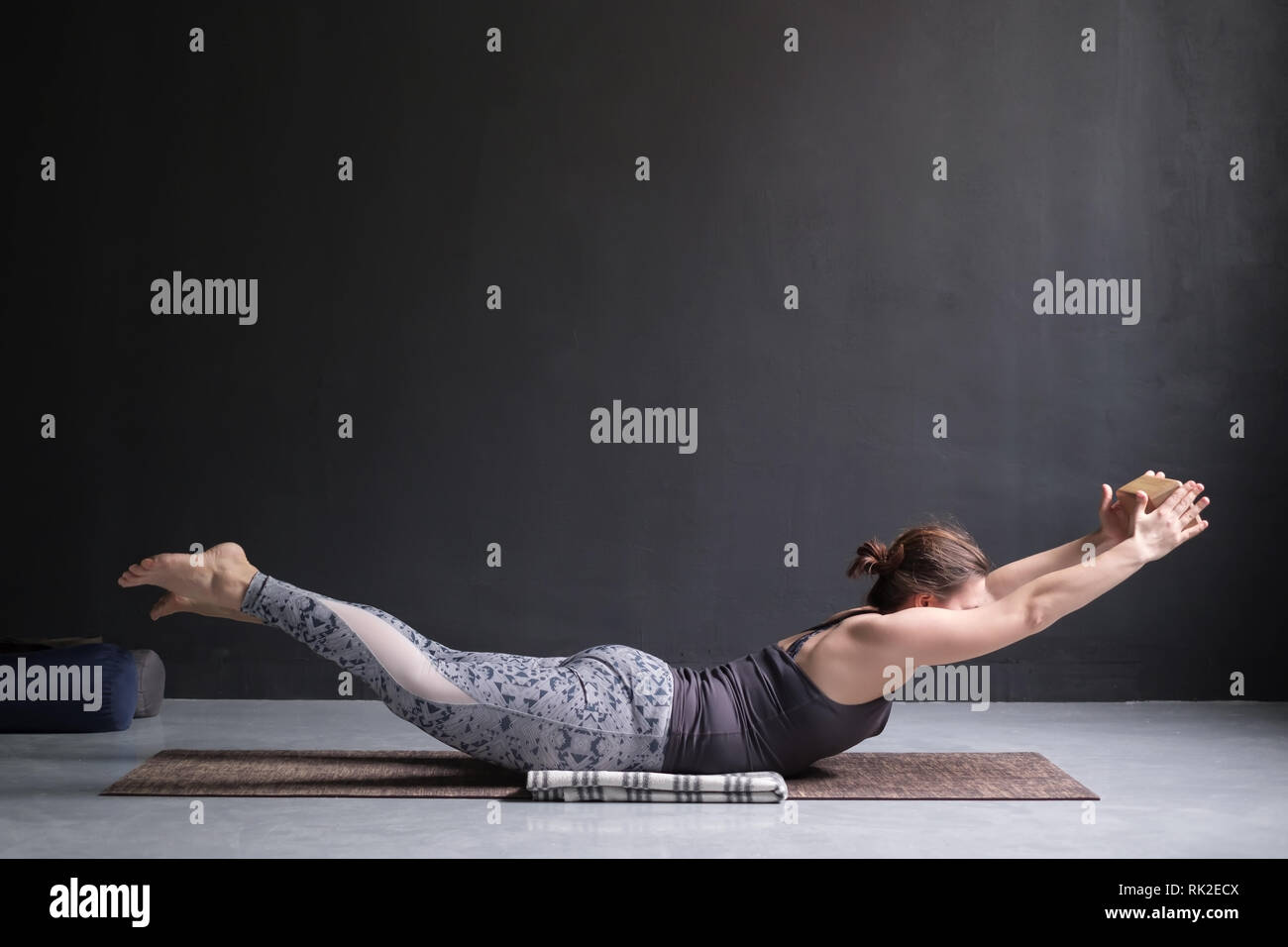 Frau Üben Yoga, Stretching in Salabhasana übung, Double Leg Kicks darstellen Stockfoto