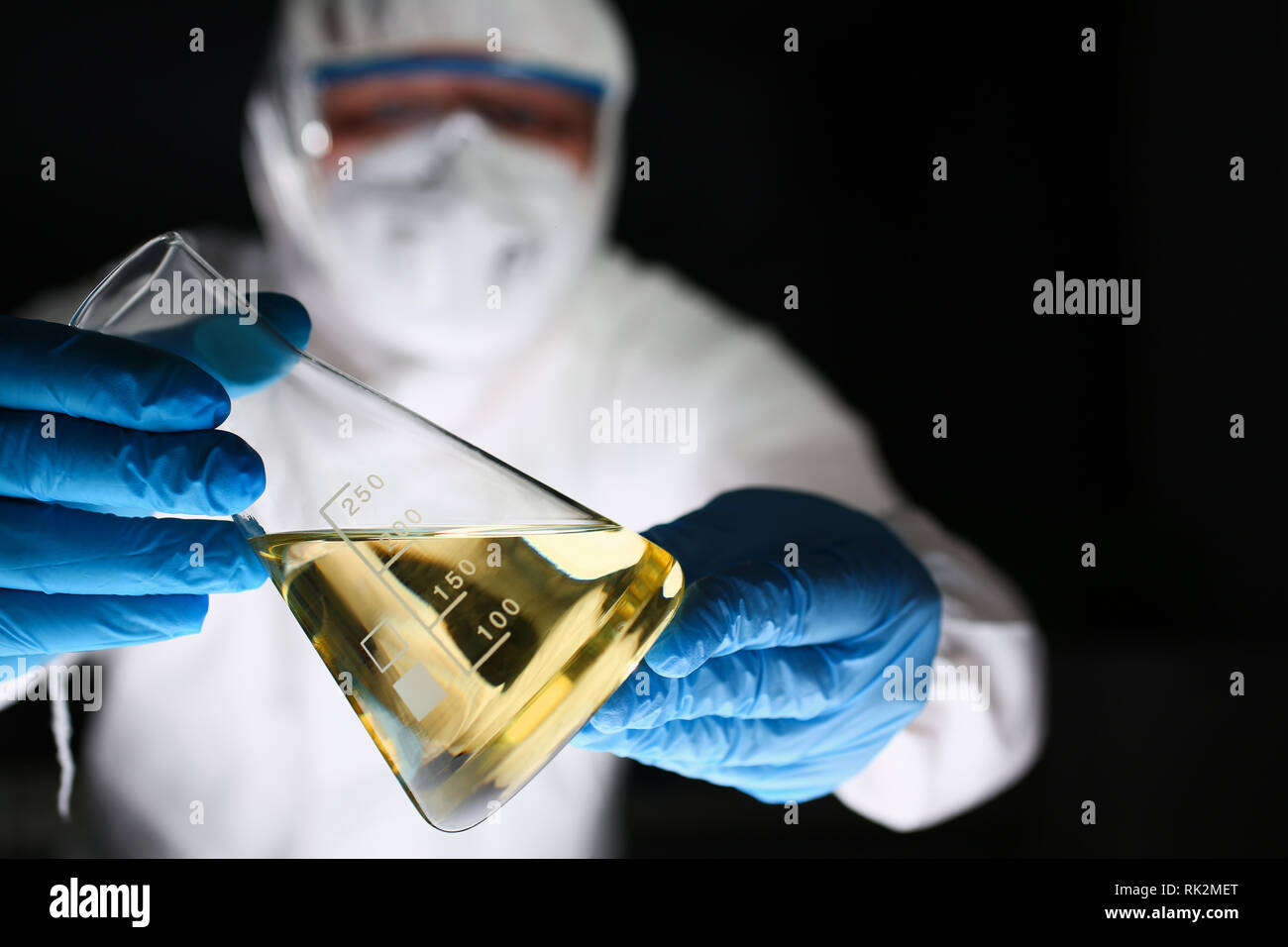 Männliche Chemiker Blick an Mikroskop halten Reagenzglas Stockfoto