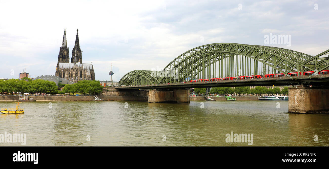 Blick auf den Kölner Dom und Hohenzollernbrücke mit Zug passiert, Köln, Deutschland. Banner Panorama. Stockfoto