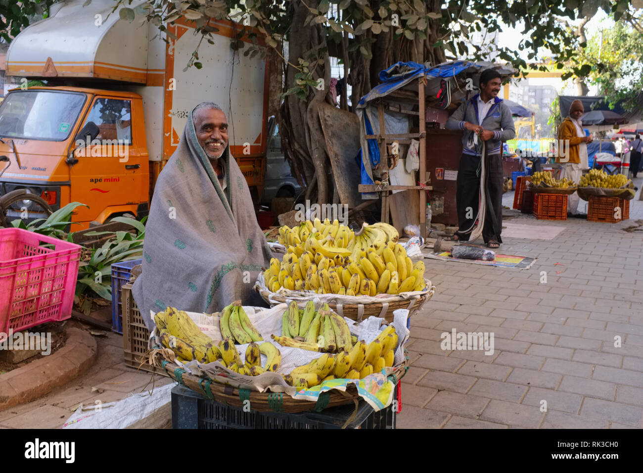 Während eine ungewöhnliche Kältewelle in Mumbai, Indien, ein strassenrand Banane Anbieter Unordnungen in seine Decke Stockfoto