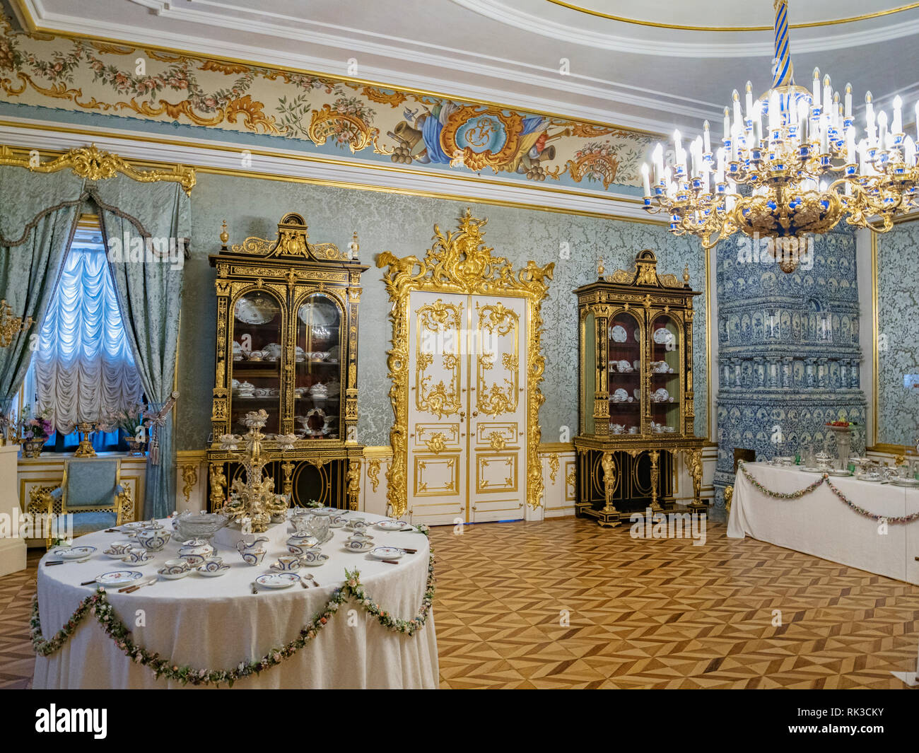 18. September 2018: St. Petersburg, Russland - Eine reich verzierte Zimmer im Schloss Peterhof, mit Kronleuchter und Tisch für Kaffee. Stockfoto