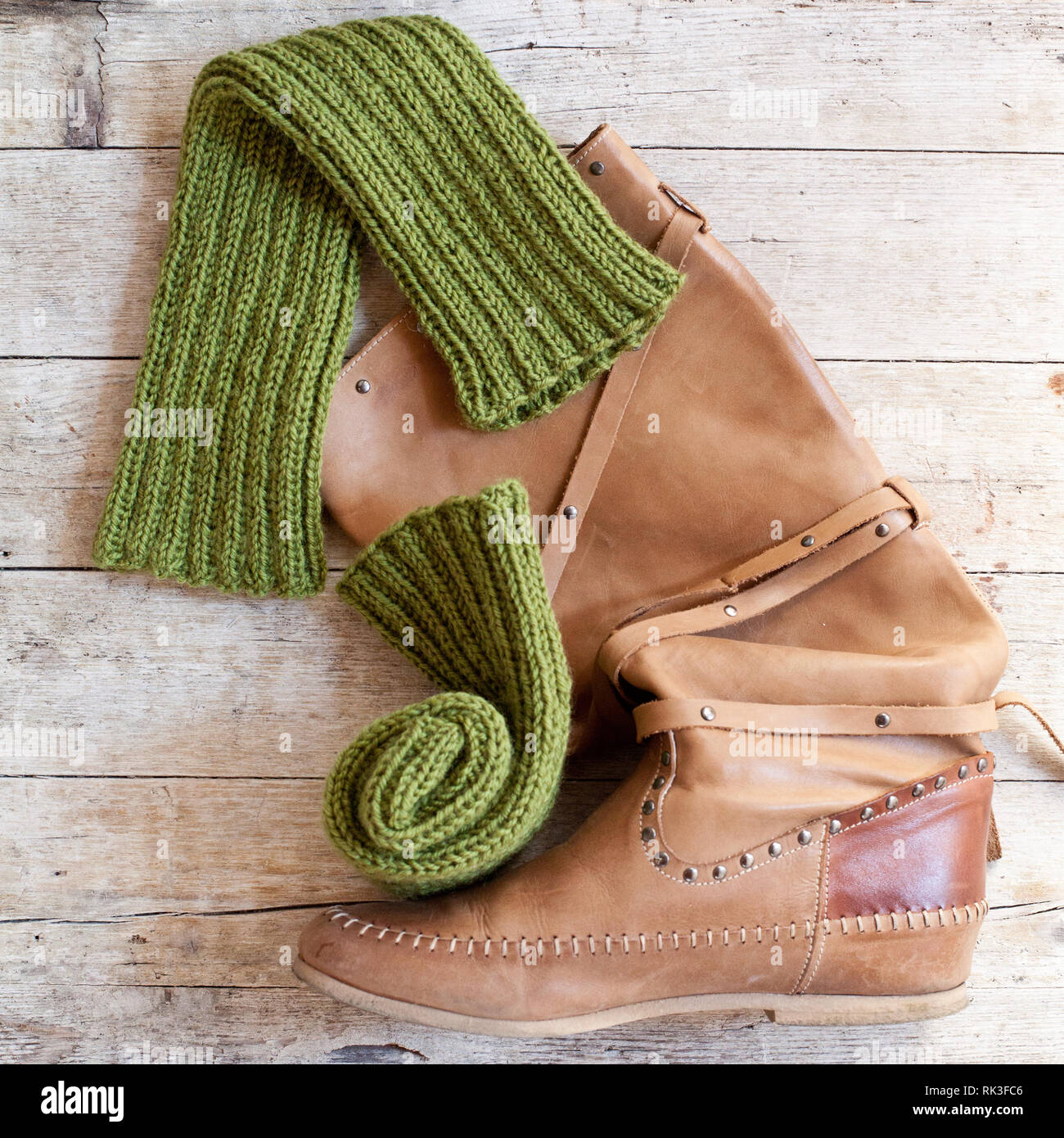 Braunes Leder Stiefel und Stulpen gestrickt Grün Holz auf Holz- Hintergrund  Stockfotografie - Alamy