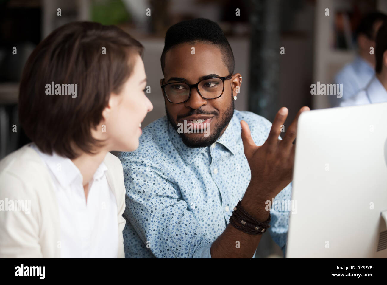 Kreative afrikanische amerikanische und kaukasische Arbeitnehmer diskutieren Arbeit chatten Stockfoto