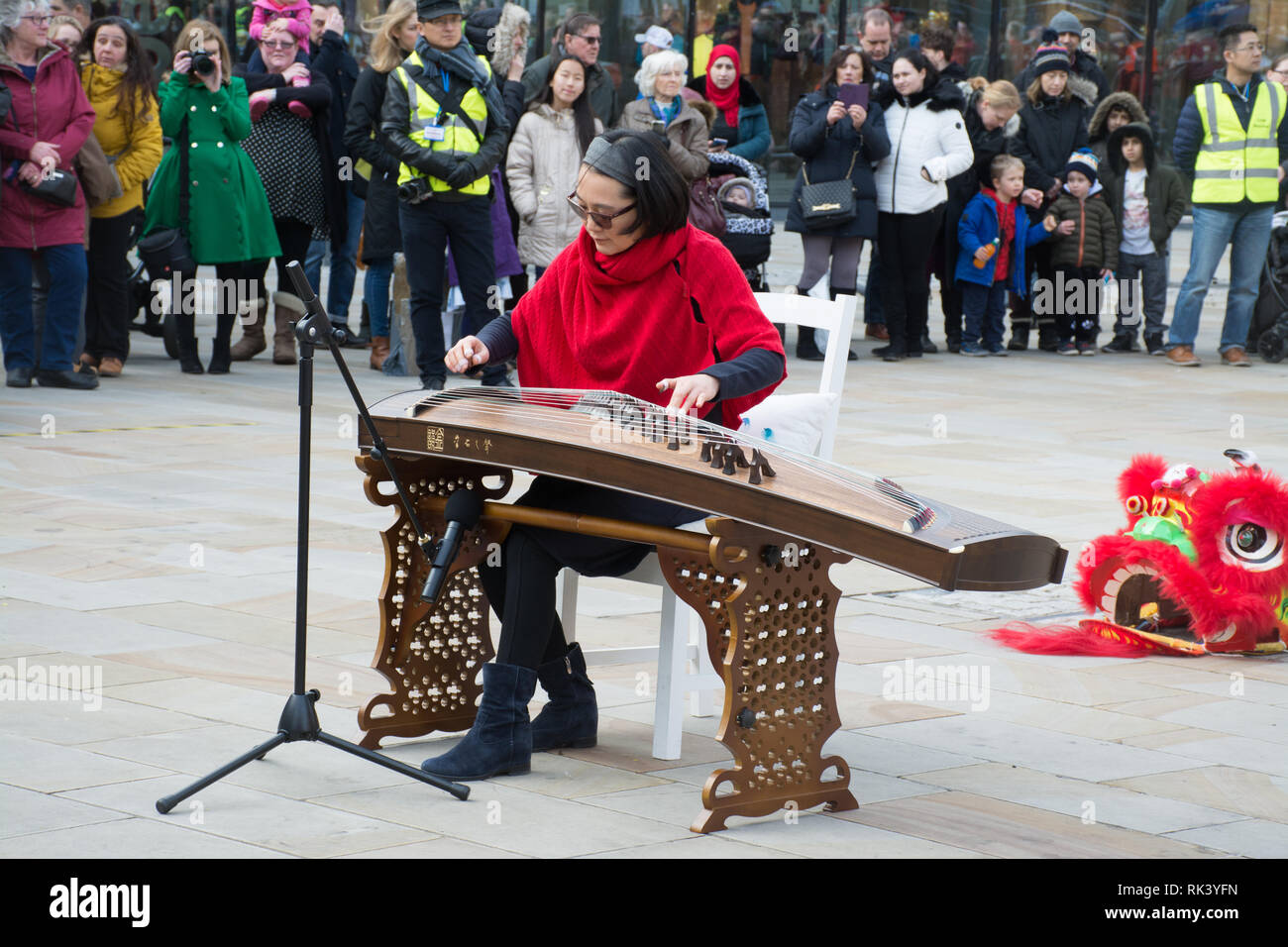 Woking, Surrey, Großbritannien. 9. Februar, 2019. Woking Zentrum feierte das Chinesische Neue Jahr des Schweins heute mit bunten Paraden und Shows. Ein solo spielen oder auf der chinesische zither Guzheng. Stockfoto