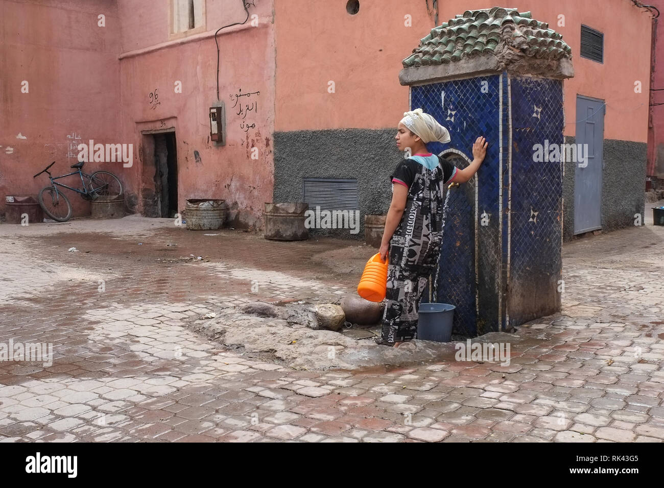 Frau am Brunnen, Marrakesch Stockfoto