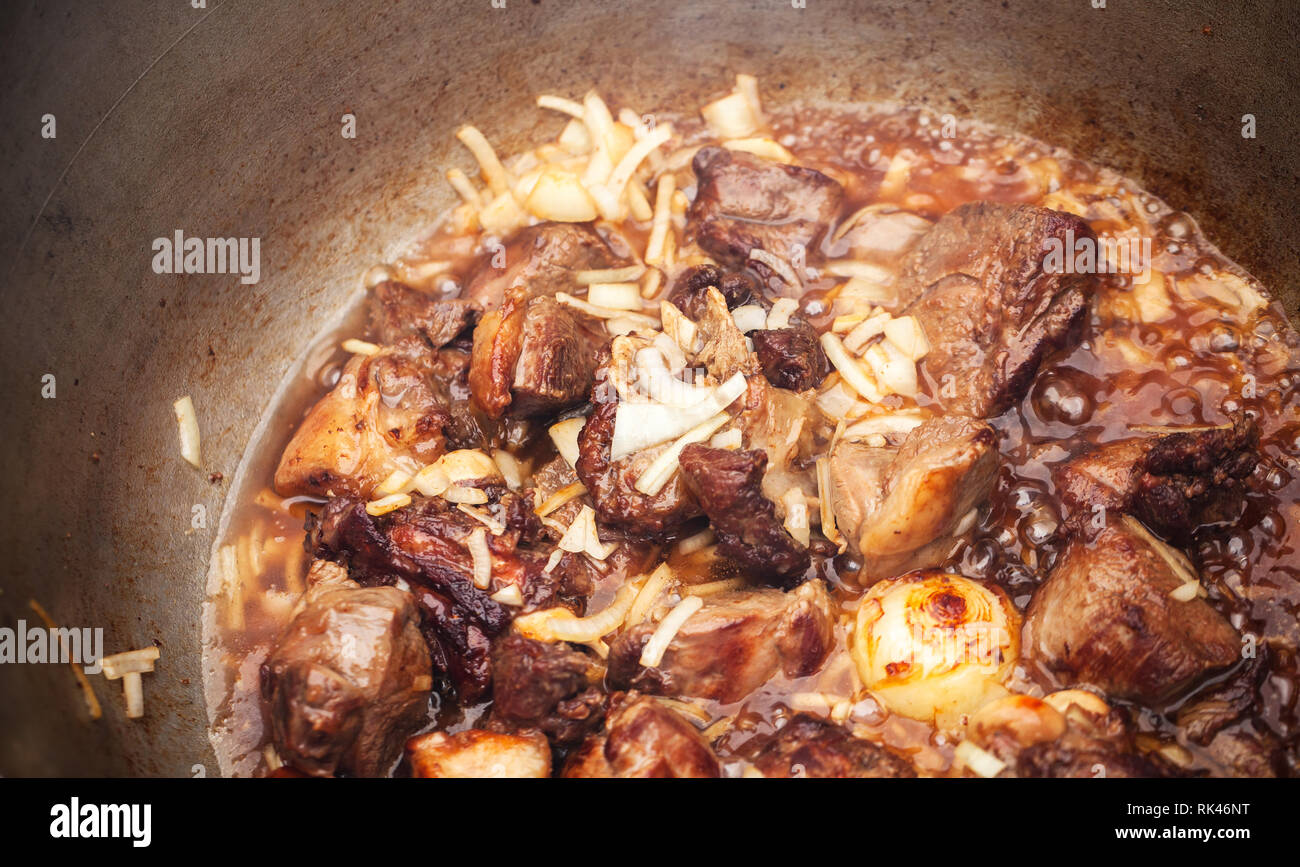 Lamm und Gemüse Kochen im Kessel. Vorbereitung der Chorba Suppe auf offenem Feuer, traditionelle Mahlzeit für viele nationale Spezialitäten, die in Europa, Afrika und Als Stockfoto