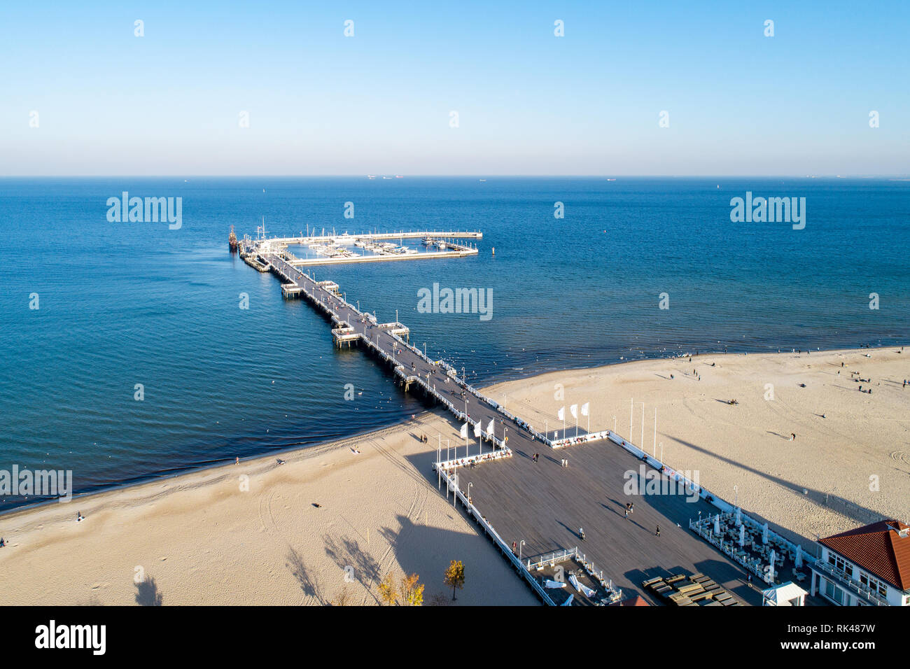 Hölzerne Seebrücke mit Hafen, Marina mit Yachten und Strand von Sopot Resort in der Nähe von Danzig in Polen im Abendlicht. Luftaufnahme Stockfoto