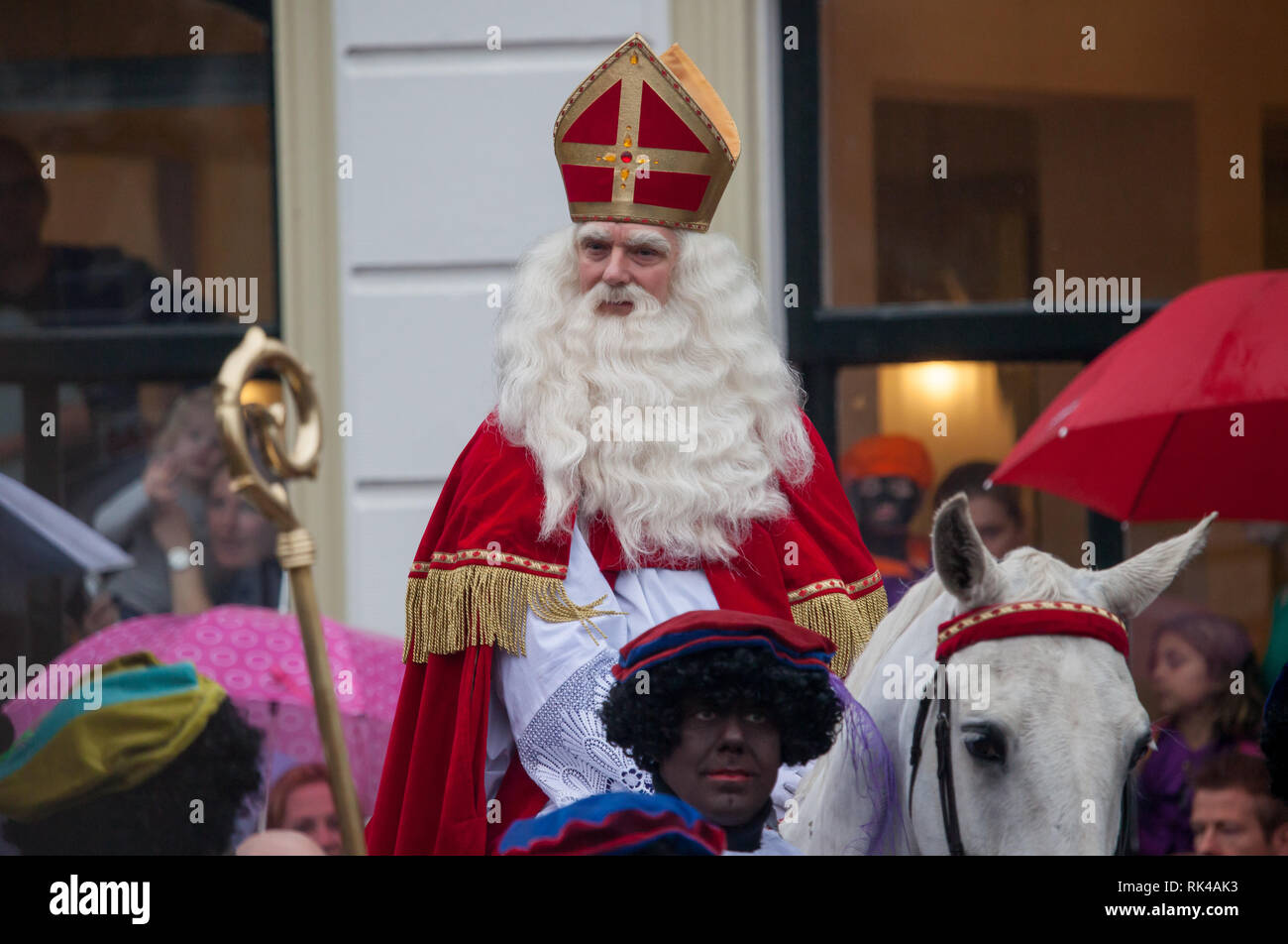 Gouda, Niederlande - 15 November 2014: Sankt Nikolaus durch die Stadt auf seinem Pferd, mit seinem Helfer (s) "zwate Piet pieten' (schwarz) Stockfoto