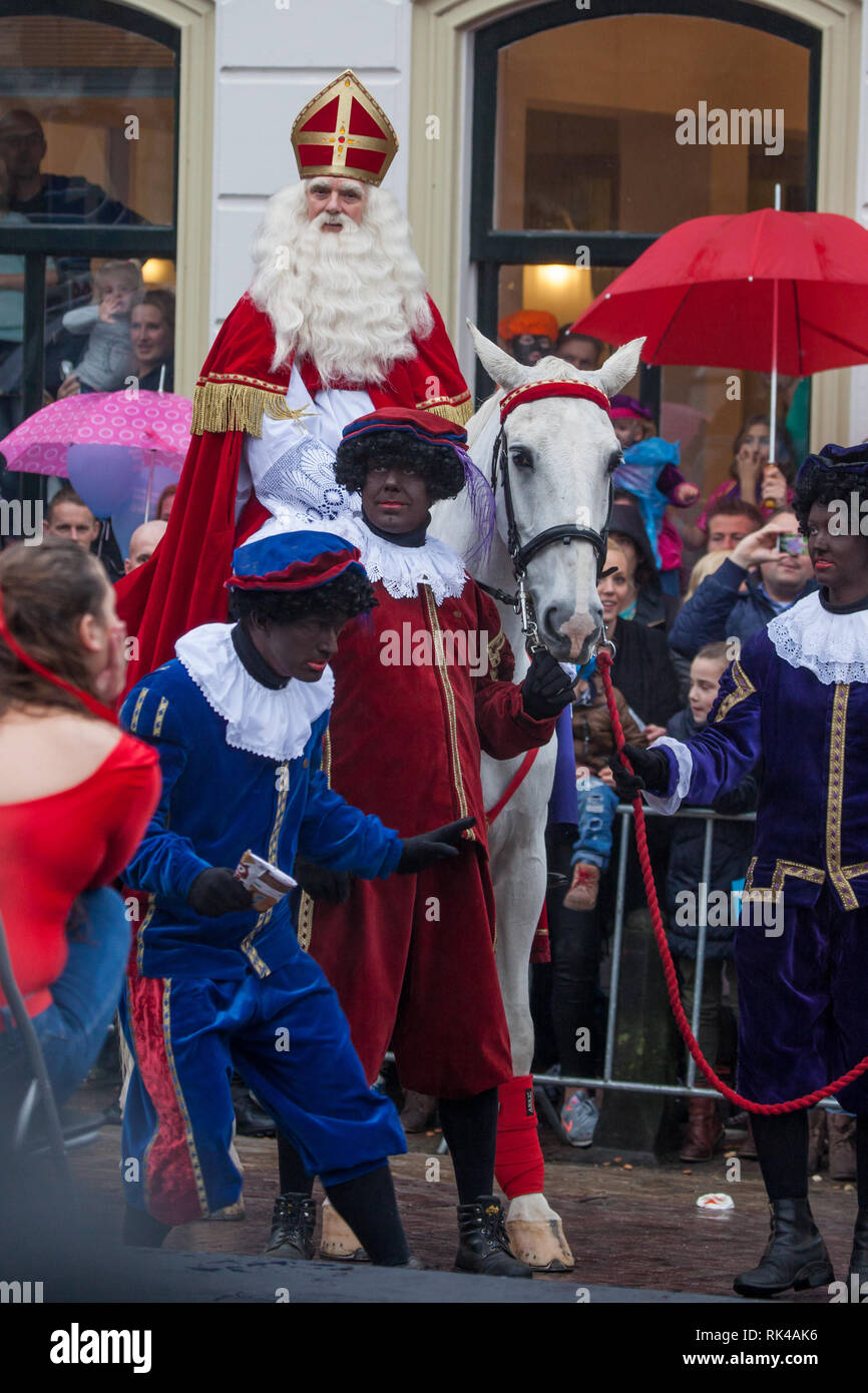 Gouda, Niederlande - 15 November 2014: Sankt Nikolaus durch die Stadt auf seinem Pferd, mit seinem Helfer (s) "zwate Piet pieten' (schwarz) Stockfoto