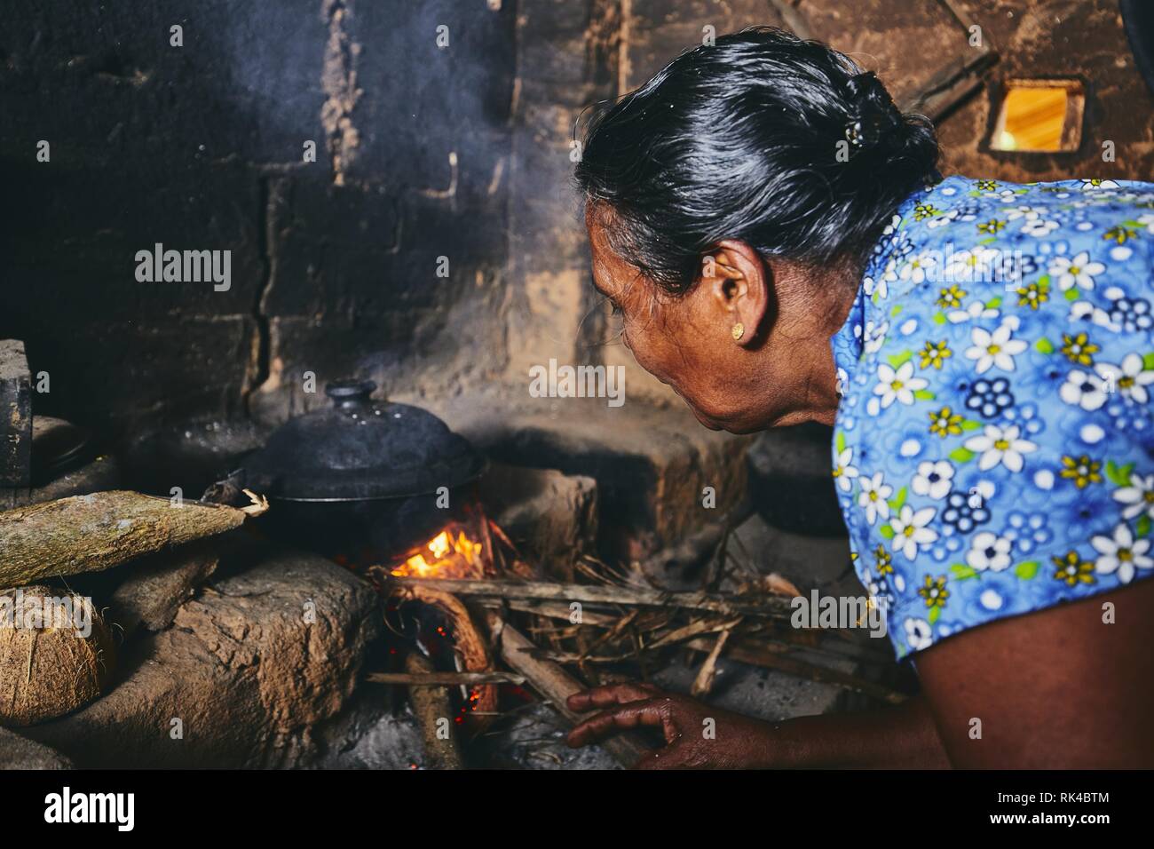 Ländliche Frau Zubereitung von Speisen in der traditionellen Küche zu Hause. Das häusliche Leben in Sri Lanka. Stockfoto