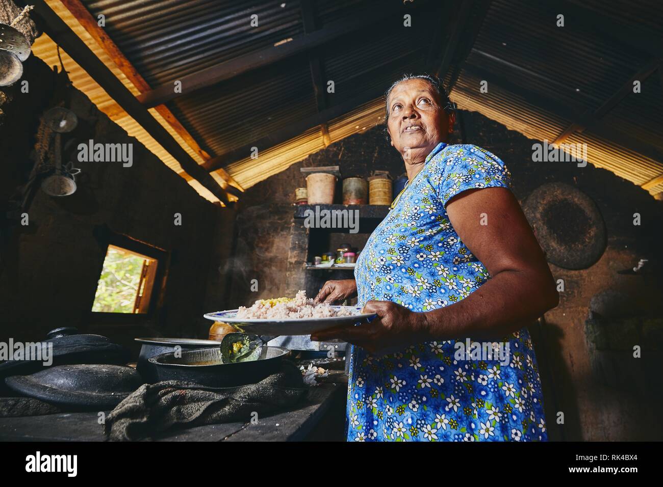 Ländliche Frau Zubereitung von Speisen in der traditionellen Küche zu Hause. Das häusliche Leben in Sri Lanka. Stockfoto