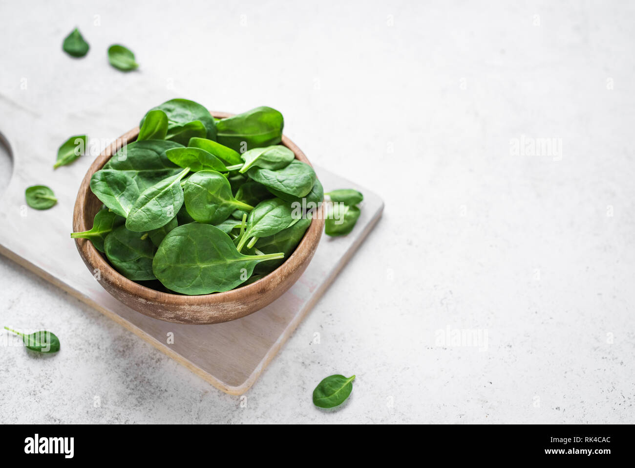 Baby Spinatblätter in der Schüssel auf weißem Hintergrund, kopieren. Sauber Essen, Detox, Diät Lebensmittel Zutat - grün Bio Spinat. Stockfoto