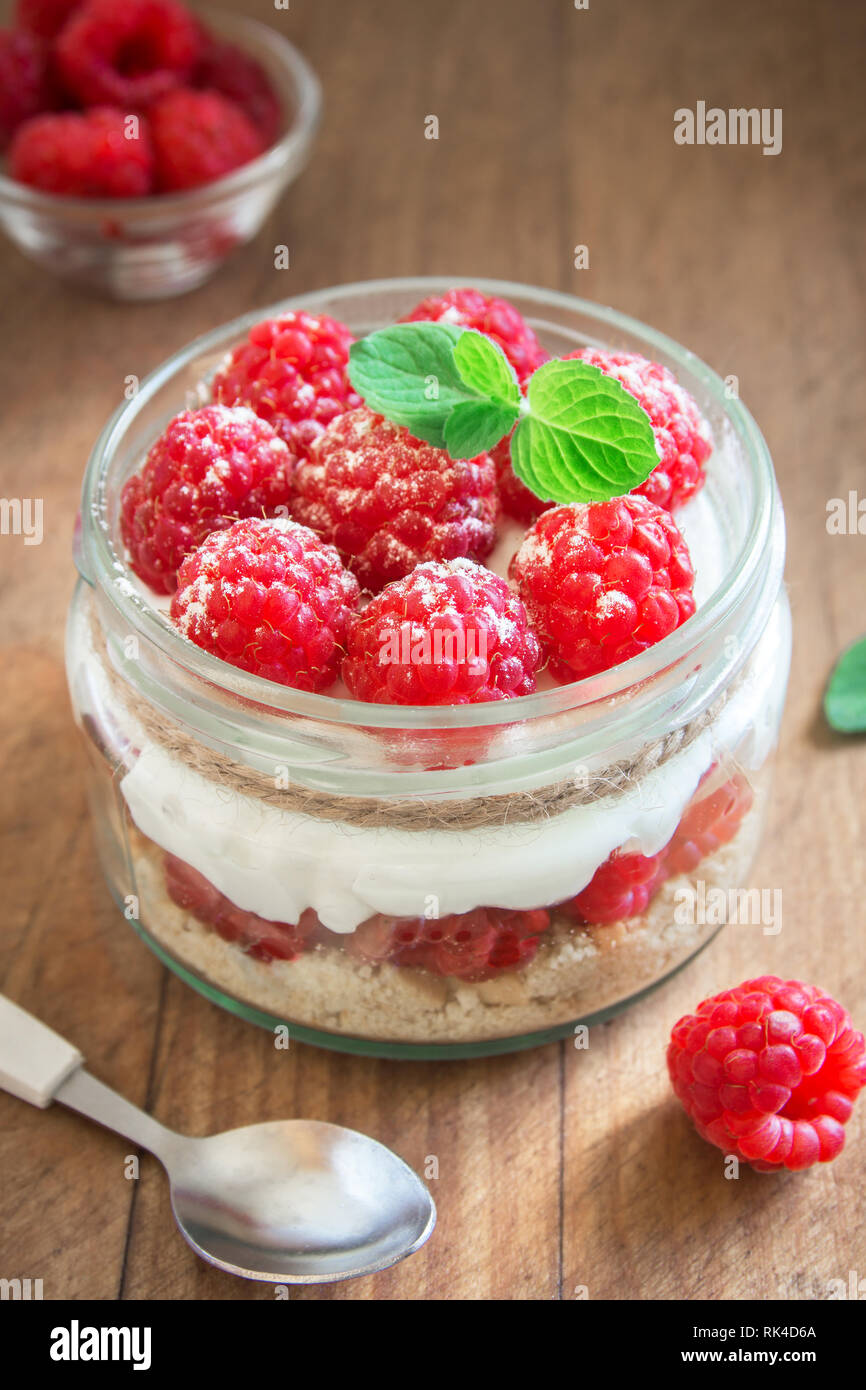 Himbeere layered Dessert - käsekuchen in Glas Glas mit frischen Himbeeren und Frischkäse. Gesunde hausgemachte Sommer berry Dessert. Stockfoto