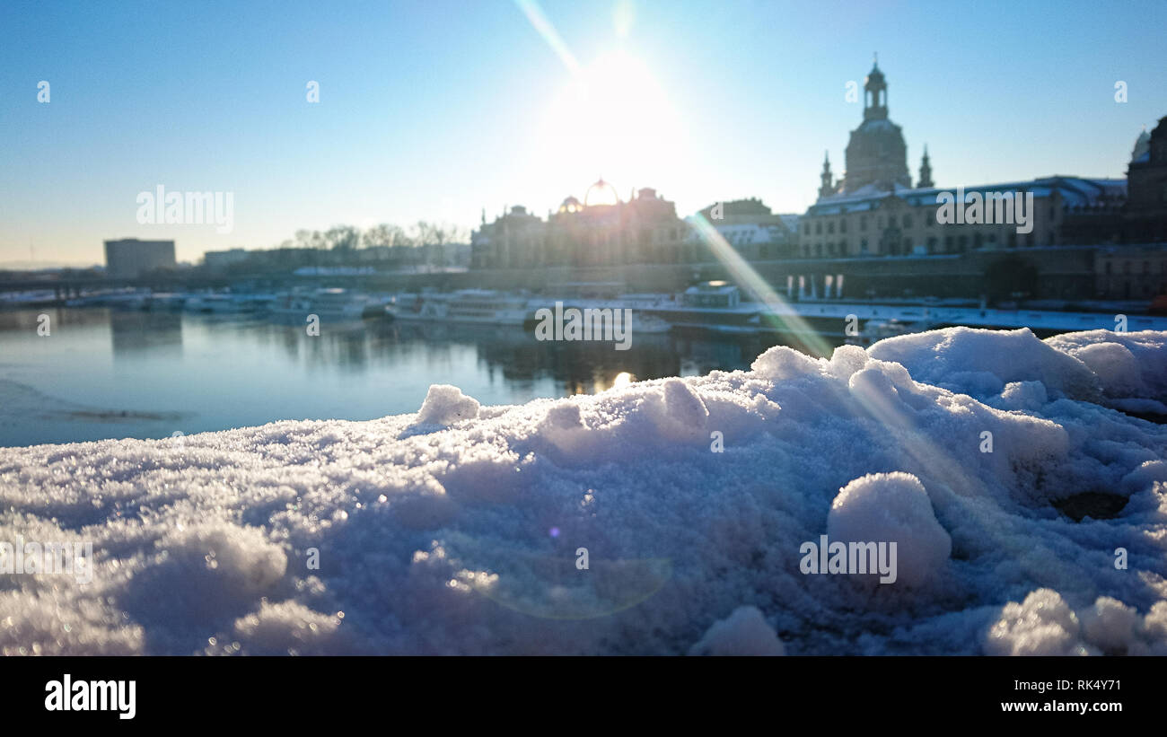 Panorama auf die Skyline von Dresden in Deutschland gesehen von einer Brücke im Schnee bedeckt mit den sonnigen blauen Himmel (unscharf) Stockfoto