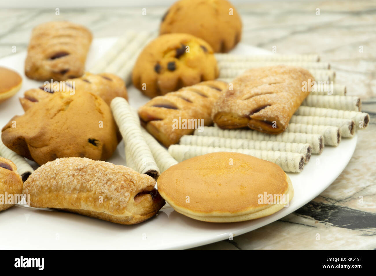 Prozess der Vorbereitung Ingwer Cookies durch einen Urlaub. Teig auf einem blauen Hintergrund gelegt, Cookies in Form von Herzen und Sterne. In einem Schuß eine Hand Stockfoto