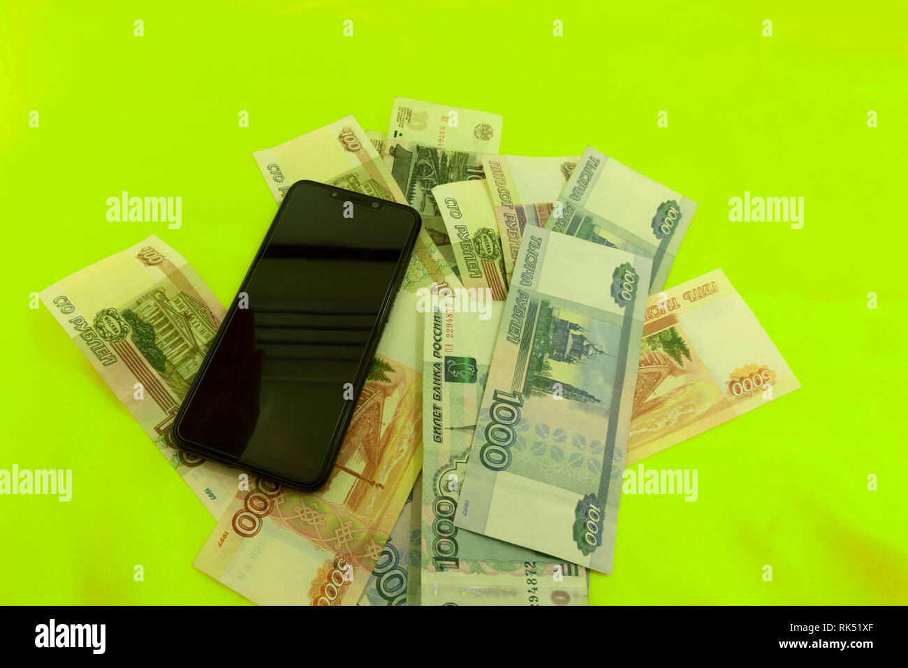 Zwei sellphones Festlegung auf Stapel von Bargeld auf weißem Hintergrund. Stockfoto