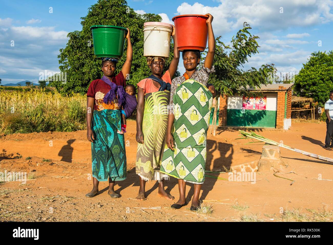 Lokale Frauen, die Eimer auf dem Kopf, Malawi, Afrika Stockfoto