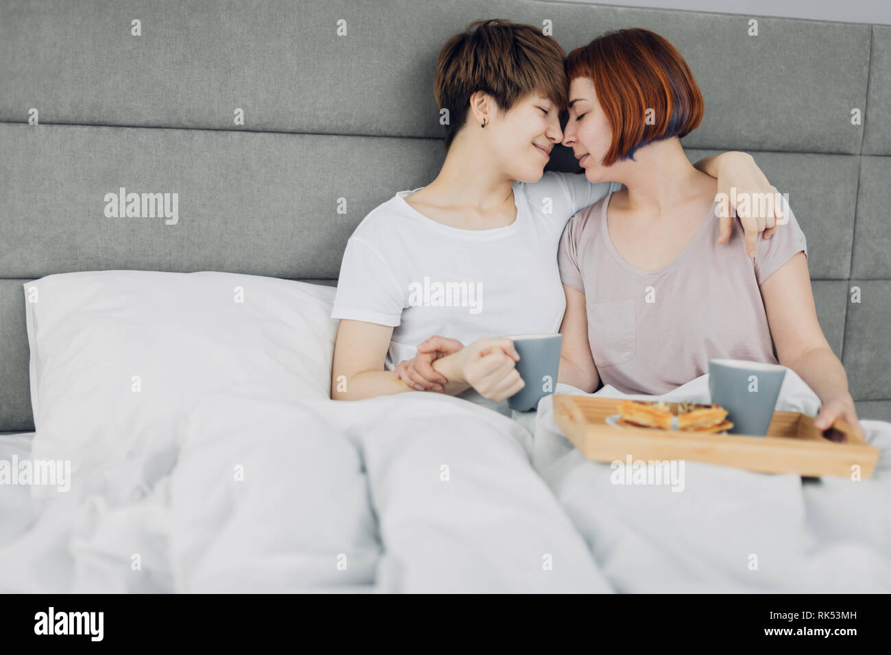 Zwei schöne Lesben genießen einen Tag im Bett