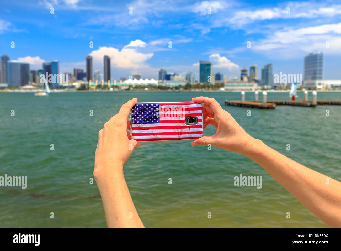 Tourismus und Reisen in Kalifornien, West Coast. Mobiltelefon mit American Flag cover Fotos von San Diego von Skyline. Smartphone shoting in Stockfoto