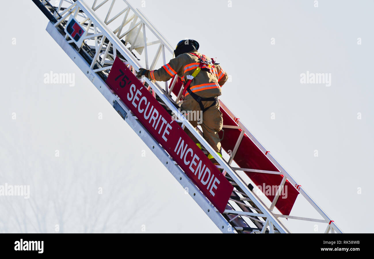 Montreal, Kanada, 9. Februar, 2019. Feuerwehrmann klettern firetruck Leiter. Credit: Mario Beauregard/Alamy leben Nachrichten Stockfoto