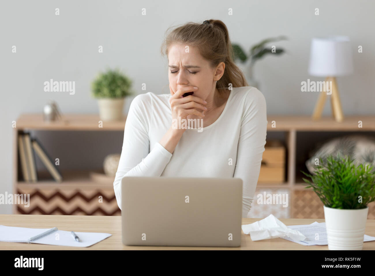 Junge müde, schläfrig Frau Gähnen studieren oder arbeiten mit Laptop Stockfoto