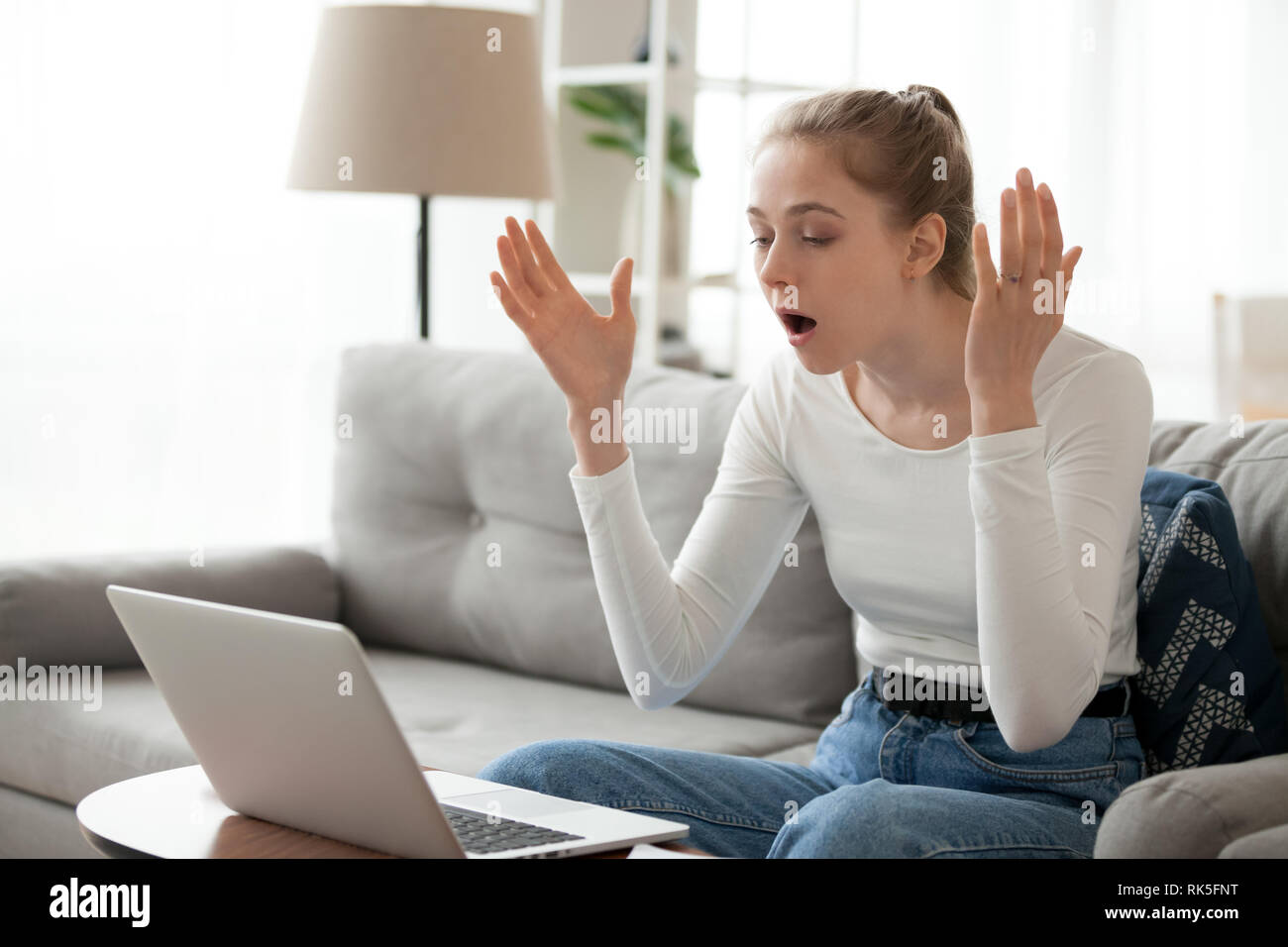 Wütend schockiert Frau über Computer Problem am Laptop genervt Stockfoto