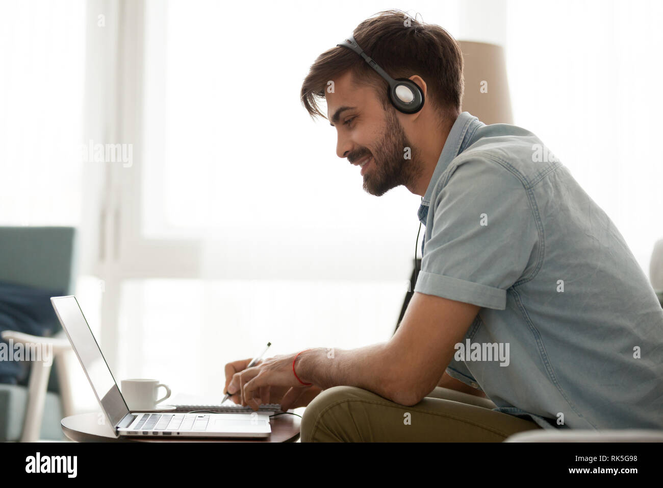Glückliche Menschen das Headset Studie online auf Laptop Notizen zu machen Stockfoto