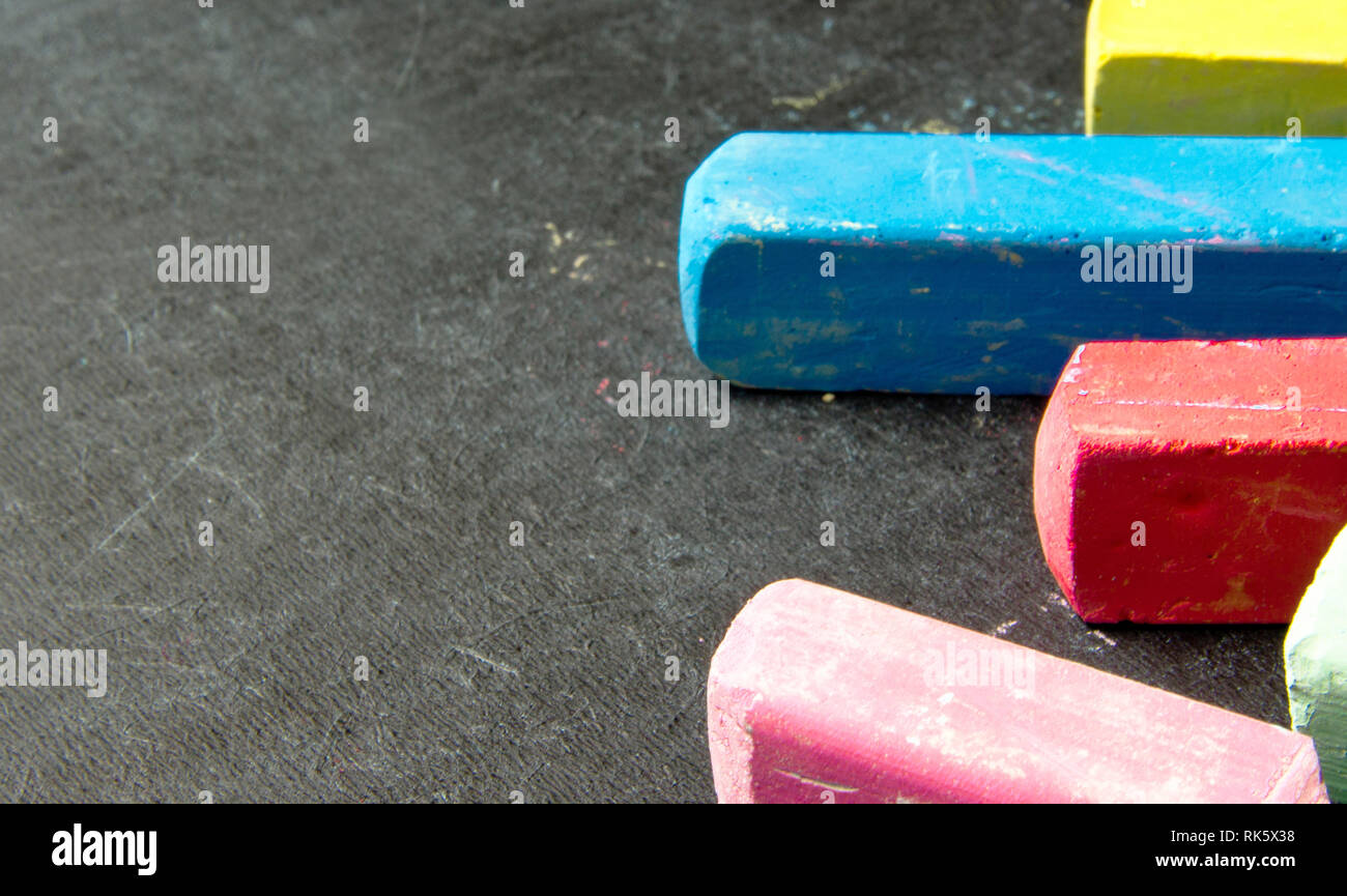 Dunkle Schiefertafel mit farbigen Kreiden für Zeichnung. Platz kopieren Stockfoto