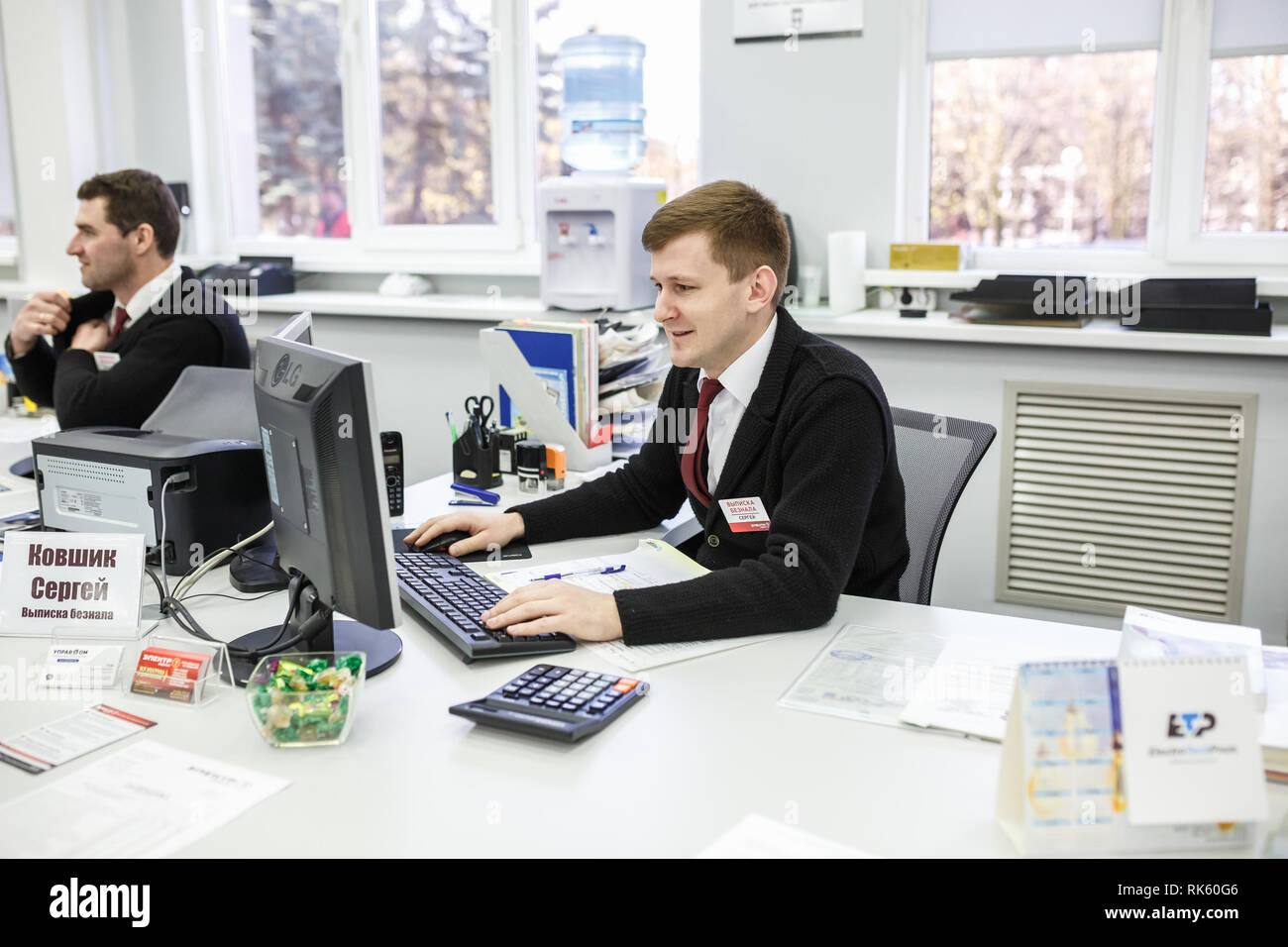 GRODNO, Weißrussland - AUGUST 2017: Mitarbeiter, um den Anruf zu beantworten im Store an der Arbeit am Computer im modernen Shop Stockfoto