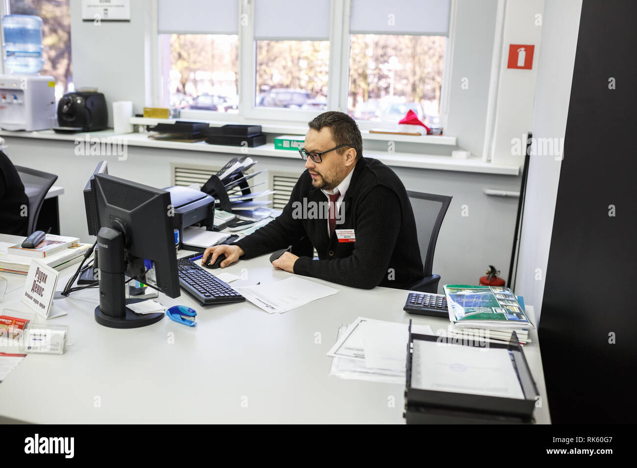 GRODNO, Weißrussland - AUGUST 2017: Mitarbeiter, um den Anruf zu beantworten im Store an der Arbeit am Computer im modernen Shop Stockfoto