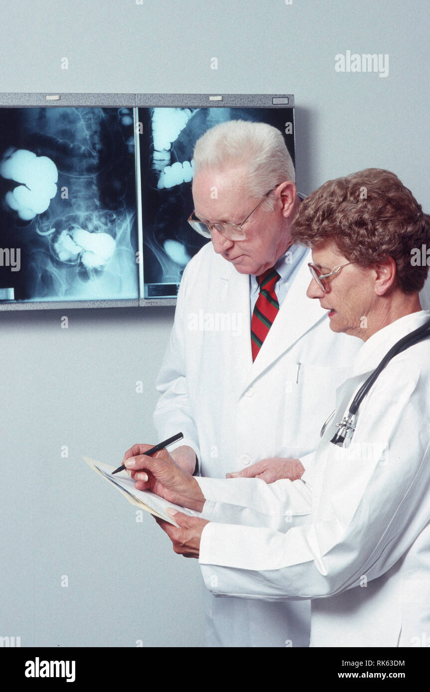 Arzt und Krankenschwester Besprechen des Patienten Fortschritte, USA Stockfoto