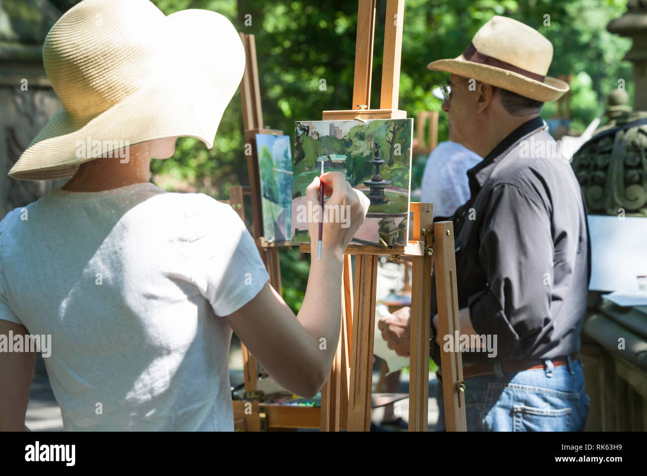 Ein Maler arbeitet auf einer Staffelei in der Malerei Klasse, Central Park, NYC Stockfoto