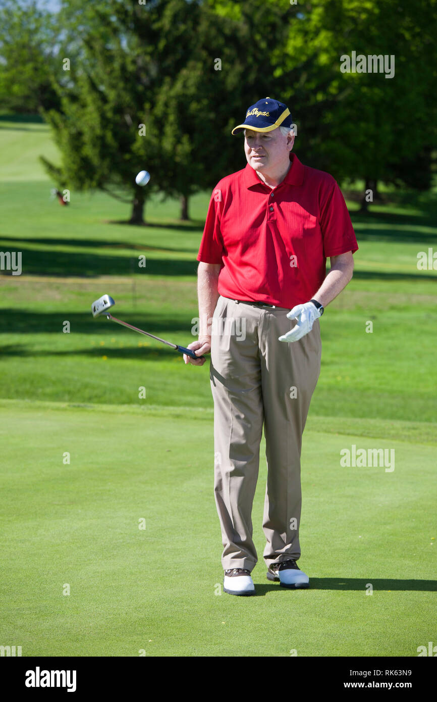 Reifen Golfspieler Bouncing Hi sBall auf seinen Putter, USA Stockfoto