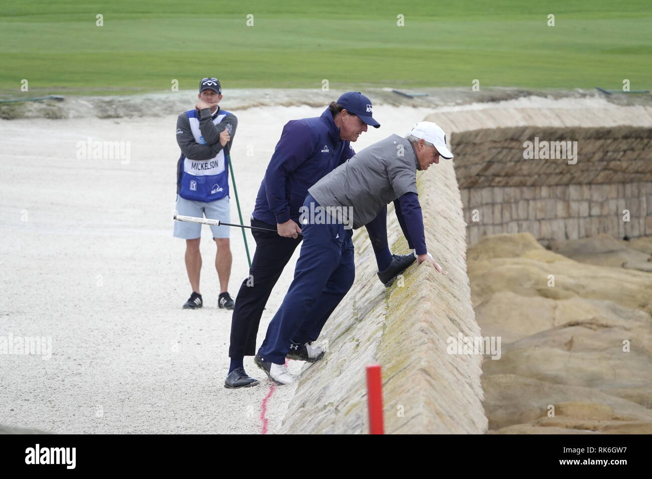 9. Februar, 2019 Pebble Beach Golf Links, CA, USA Phil Mickleson und laienhaften Partner Scott Ozanus strike a Pose auf dem Meer wand Abwehr des 18. Als er versucht zu finden, Partner Patrick Reed's errant Kugel während der dritten Runde in Pebble Beach Golf Course während der AT&T Pro-Am Credit: Motofoto/Alamy leben Nachrichten Stockfoto