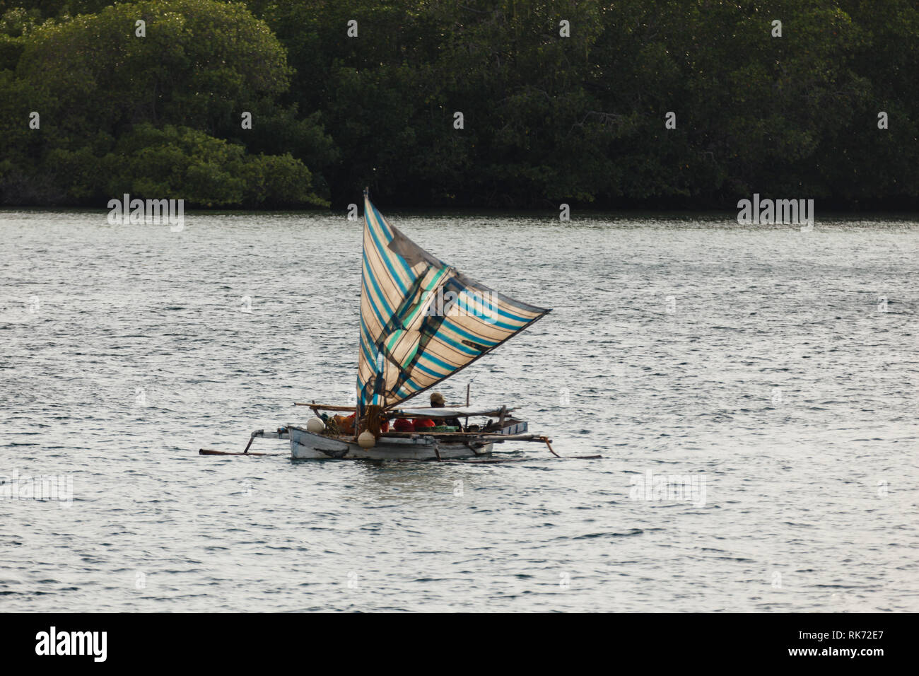 Native outrigger Segelboot kreuze Wasser zwischen den Inseln zu fischen. Stockfoto