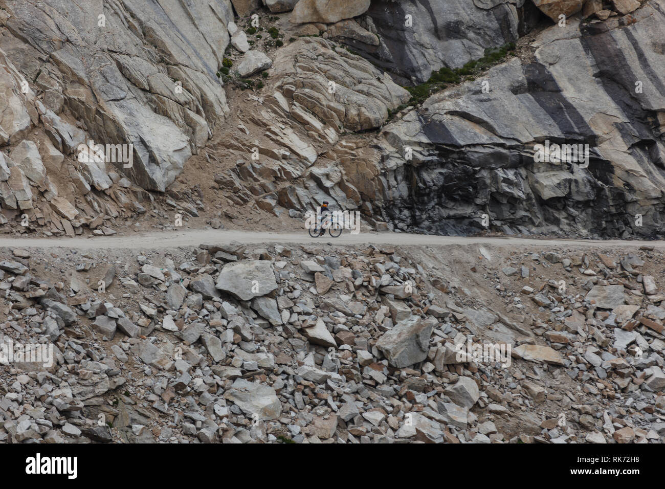Single rider Mountainbike durch die unbewohnte Khardungla Durchlauf in Himalaya, Indien auf einem schmalen Feldweg Stockfoto