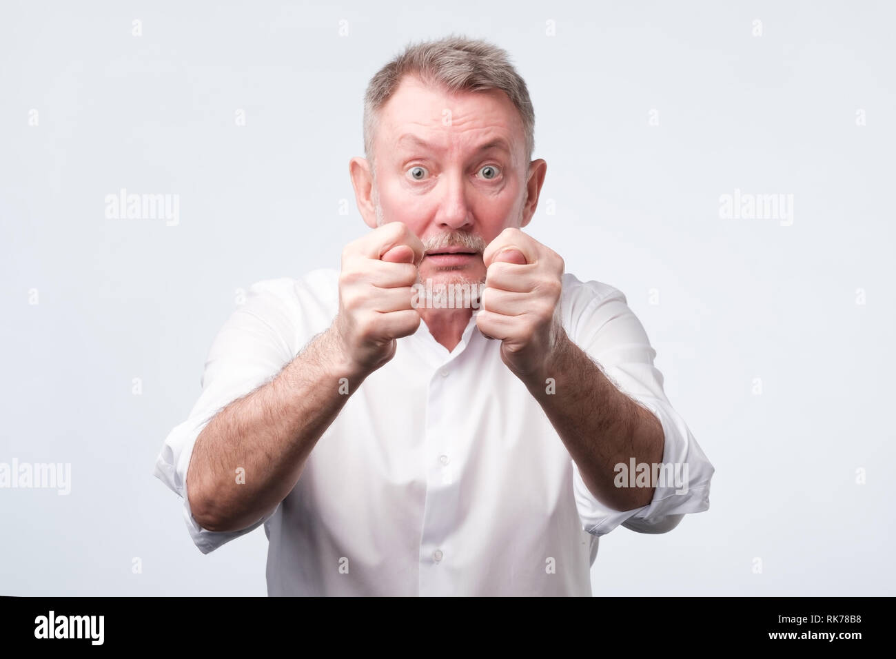 Älterer Mann im weißen Hemd zeigt die Abb. Stockfoto
