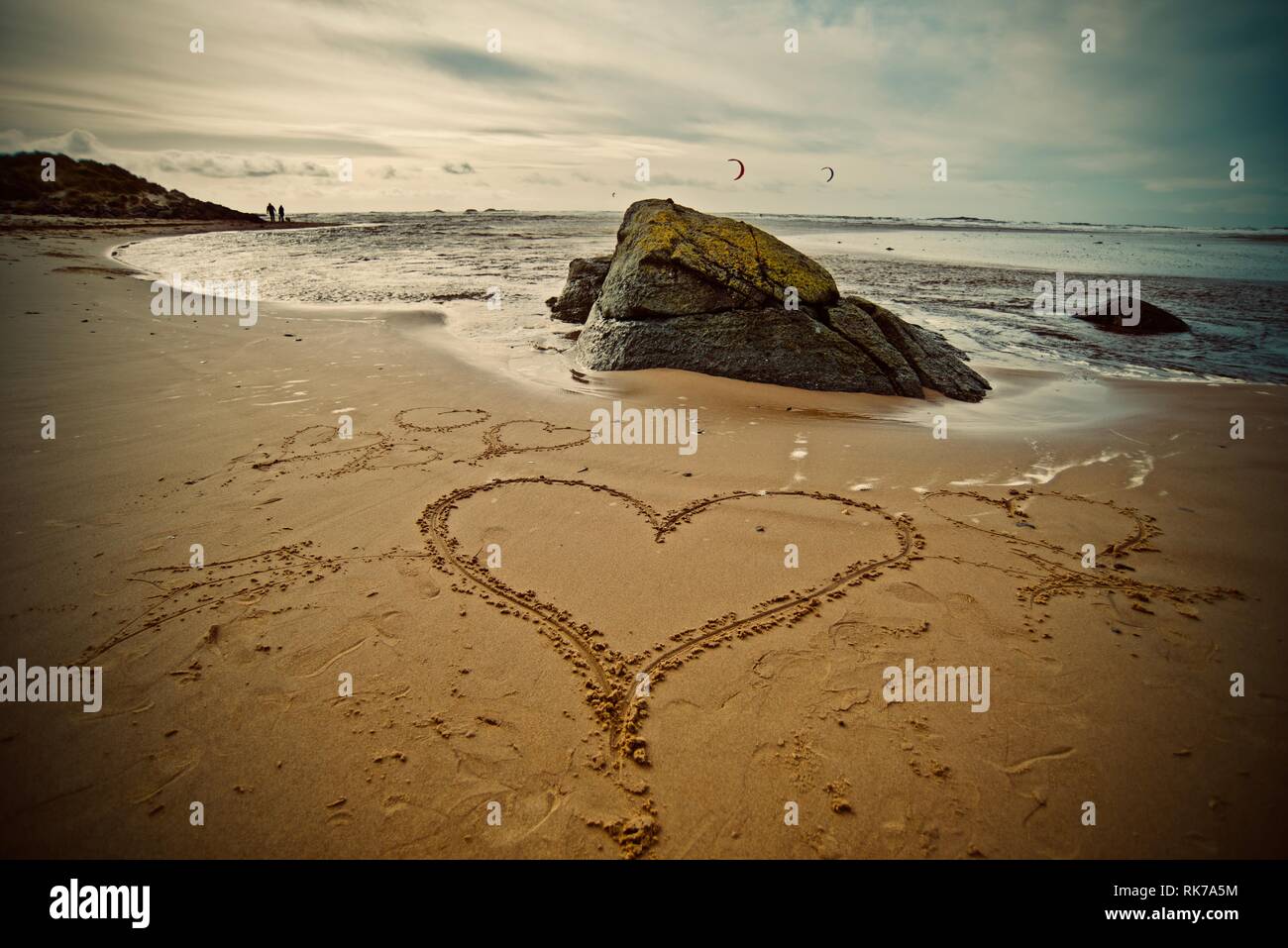 Lieben den Strand, das Meer lieben. Ein Herz in den Sand des Strandes mit der Tide, die hereinkommen, Rhosneigr, Anglesey, North Wales, UK gezeichnet Stockfoto