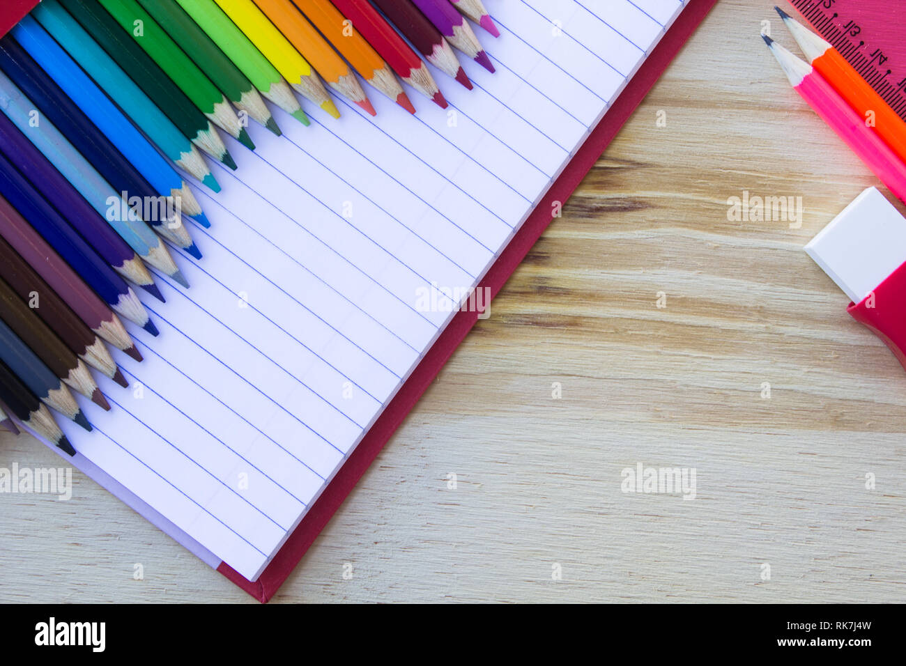 Schule und Zeichnung liefert, auf hölzernen Tisch. Übungen Buch, Buntstifte, Radiergummi und Lineal. Mit kopieren. Stockfoto