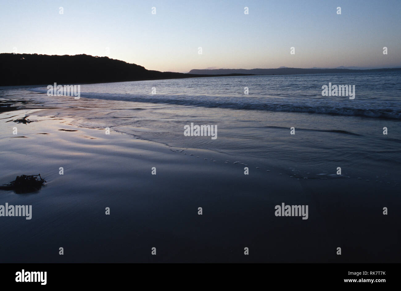 Bildunterschrift: Bruny Island, Tasmanien, Australien - Jan 2003. Cloudy Bay, am südlichen Strand auf Bruny Island, bei Sonnenuntergang. In einem großen Crescent m Geschützten Stockfoto